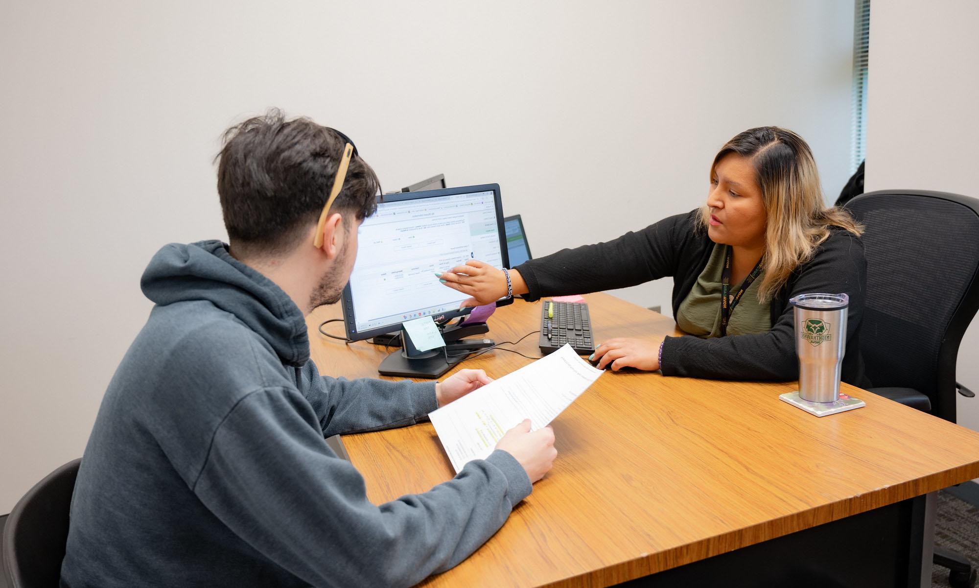 student meeting with an advisor at their office